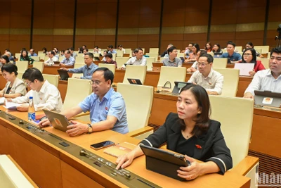 Các đại biểu Quốc hội bấm nút thông qua việc điều chỉnh Chương trình Kỳ họp thứ 9, Quốc hội khóa XV. (Ảnh: BÙI GIANG)