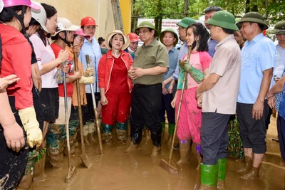 Thủ tướng Phạm Minh Chính thăm hỏi, động viên các cô giáo Trường Mầm non Hoa Lan (thành phố Yên Bái) đang dọn dẹp bùn đất tại trường. (Ảnh: Trần Hải)