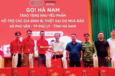 Nhân viên Central Retail trao tặng nhu yếu phẩm cho người dân bị ảnh hưởng bởi bão lũ.