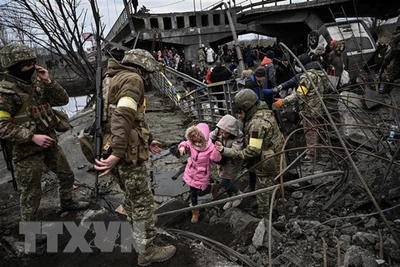 Người dân sơ tán khỏi thành phố Irpin, tây bắc thủ đô Kiev, Ukraine. (Ảnh: AFP/TTXVN)