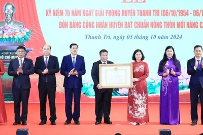 Phó Bí thư Thường trực Thành ủy Hà Nội Nguyễn Thị Tuyến trao Bằng công nhận huyện Thanh Trì đạt chuẩn nông thôn mới nâng cao cho lãnh đạo huyện Thanh Trì. (Ảnh: Quang Thái)