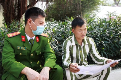 Một phạm nhân đọc thư mẹ gửi với cán bộ Trại giam Yên Hạ (Sơn La).