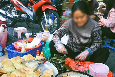 Một hàng đồ ăn trên đường không được che đậy cẩn thận. (Ảnh TUỆ NGHI)