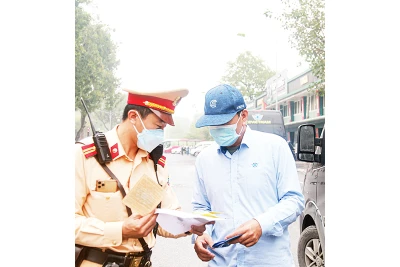 Cảnh sát giao thông thành phố Hà Nội kiểm tra, xử phạt các xe limousine đón trả khách tại khu vực cổng Rạp xiếc Trung ương trên phố Trần Nhân Tông. (Ảnh LÊ KHÁNH)