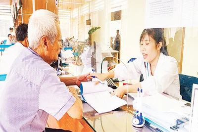 Cán bộ bộ phận "một cửa" Ủy ban nhân dân huyện Quốc Oai hướng dẫn người dân làm thủ tục. (Ảnh THÁI SAN)