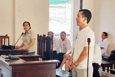 Ông L. M. T (đứng bên phải), con của bà T. T. S và ông L. T. H - người có quyền lợi và nghĩa vụ liên quan đến vụ án và bà Nguyễn Thu Hà (đứng bên trái) tại phiên tòa, sáng 25/10.