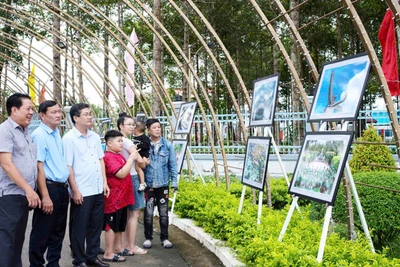 Người dân và chính quyền địa phương tham quan triển lãm ảnh. (Ảnh: HUỲNH LÃNH).