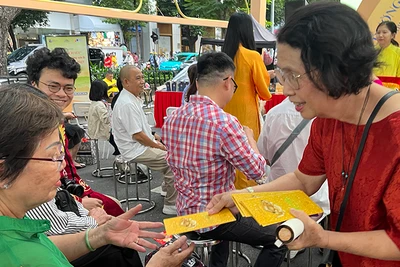 Tiến sĩ Quách Thu Nguyệt lì xì sách cho người dân tham dự chương trình.