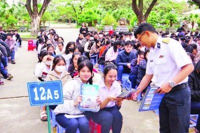 Báo cáo viên tuyên truyền, phát tờ rơi về thu hút nguồn nhân lực tại Trường THPT Hùng Vương, thành phố Quy Nhơn. (Ảnh THANH SANG)