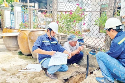 Nhân viên Xí nghiệp cấp nước Cần Giờ gắn đồng hồ nước thông minh thay cho đồng hồ cũ cho các hộ dân tại xã Tam Thôn Hiệp, huyện Cần Giờ.