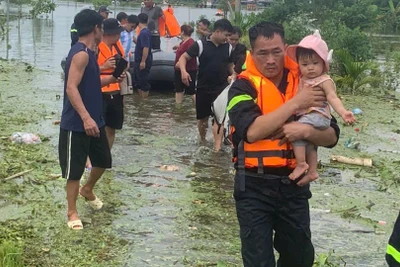 Cảnh sát PCCC trên sông bế em bé di dời về nơi an toàn. 