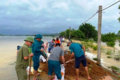 Lực lượng chức năng đắp đập ngăn lũ. (Ảnh: Kim Thoa)