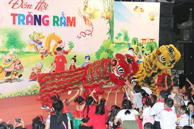 Các em thiếu nhi hào hứng thưởng thức tiết mục múa lân. (Ảnh: HẢI TIẾN)