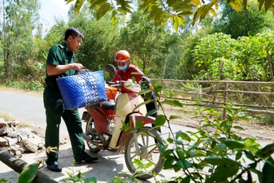 Cán bộ, chiến sĩ Ðồn Biên phòng cửa khẩu quốc tế Dinh Bà giúp người dân trong cuộc sống hằng ngày. 