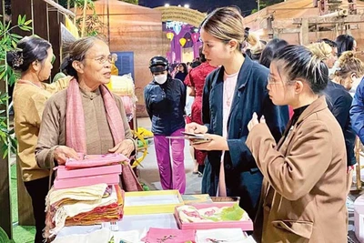 Các nghệ nhân giới thiệu sản phẩm lụa Vạn Phúc với khách du lịch.