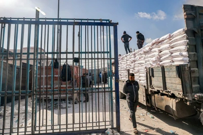 Bốc dỡ hàng viện trợ từ xe tải của UNRWA tại thành phố Rafah, Dải Gaza. (Ảnh: AFP/TTXVN)