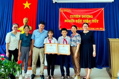 Phó Giám đốc Sở Giáo dục và Đào tạo tỉnh Đồng Nai Đỗ Đăng Bảo Linh tặng Giấy khen cho 2 em học sinh.