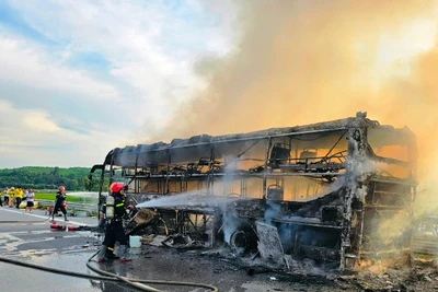 Cảnh sát sử dụng vòi rồng dập lửa trên xe ô-tô khách. 