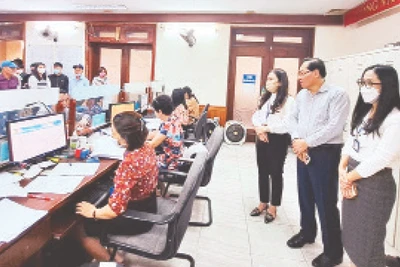 Đoàn kiểm tra công vụ thành phố kiểm tra thực tế việc tiếp nhận, giải quyết thủ tục hành chính tại bộ phận “một cửa” thuộc Sở Tư pháp Hà Nội trong ngày 7/4. (Ảnh LINH CHI)