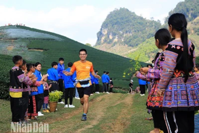 Học sinh dân tộc H'Mông đứng hai bên đường cổ động và tặng hoa cho các vận động viên.