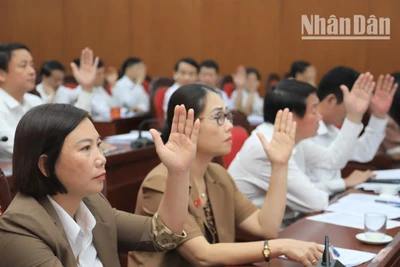 Các đại biểu Hội đồng nhân dân tỉnh Sơn La biểu quyết thông qua nghị quyết kỳ họp.