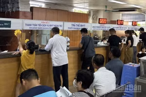 Người dân đăng ký khám, chữa bệnh bảo hiểm y tế tại bệnh viện. (Ảnh: ĐỖ THOA)