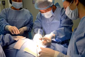 Phó Giáo sư, Tiến sĩ Trần Ngọc Lương, nguyên Giám đốc Bệnh viện Nội tiết Trung ương trực tiếp thực hiện ca phẫu thuật cho bệnh nhân. (Ảnh: HOA QUỲNH)