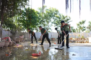 Đại úy Nguyễn Văn Kiên (ngoài cùng bên phải) cùng đồng đội hỗ trợ khắc phục hậu quả bão lũ tại chùa An Lạc.