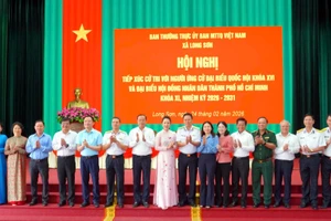 Các ứng cử viên Đại biểu Quốc hội và Hội đồng nhân dân Thành phố Hồ Chí Minh chụp ảnh với đại diện cử tri và chính quyền xã Long Sơn. 