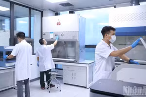 Kỹ thuật viên thực hiện các bước trong quy trình giám định ADN mẫu hài cốt liệt sĩ. (Ảnh: THANH TÚ)
