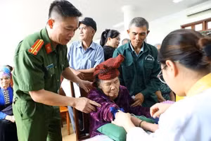 Cán bộ Phòng PC06 Công an tỉnh Điện Biên hỗ trợ các thân nhân liệt sĩ khi lấy mẫu tại nhà khách Trúc An, phường Điện Biên Phủ. (Ảnh: LÊ LAN)
