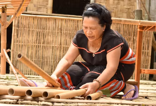 Nghệ nhân Y Sinh thực hiện thao tác làm đàn Klông Pút - nhạc cụ truyền thống của người Xơ-đăng. (Ảnh: Báo Dân tộc và phát triển)