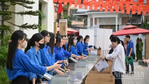 Các thí sinh kiểm tra tư trang trước khi bước vào phòng thi. (Ảnh: THẾ ĐẠI)