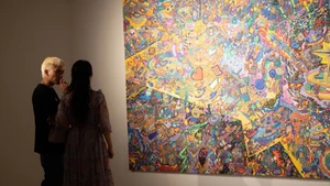 Họa sĩ Hoàng Anh Trung chia sẻ với phóng viên về quá trình sáng tạo. (Ảnh: Mơ Art Space)