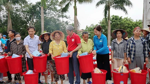 Lãnh đạo cùng các tình nguyện viên Chữ thập đỏ trao hàng thiết yếu tới nhân dân vùng thiệt hại do thiên tai ở Thanh Hóa.