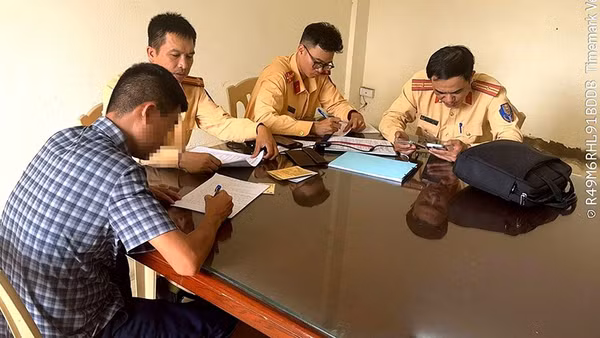 Cảnh sát giao thông lập biên bản về hành vi vi phạm của người điều khiển ô-tô.