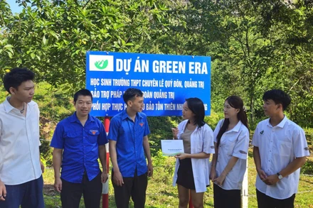 Bốn em trong nhóm Dự án Green Era trao tiền, phối hợp Đoàn Thanh niên Khu bảo tồn Thiên nhiên Đakrông chăm sóc vườn cây. (Ảnh: Quang Huy)