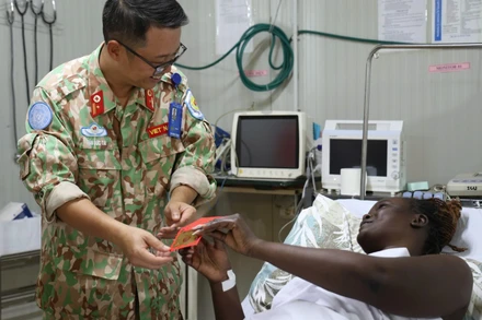  Thiếu tá Trần Đức Tài, Giám đốc Bệnh viện dã chiến cấp 2 số 7 thăm hỏi, chúc Tết các bệnh nhân đang điều trị tại bệnh viện. (Ảnh: TIẾN PHÚC)