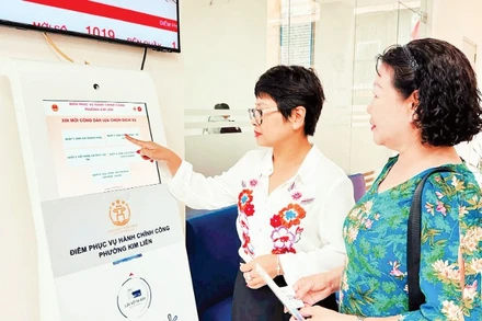 Hướng dẫn người dân lấy số thứ tự để thực hiện thủ tục hành chính tại Điểm tiếp nhận, phục vụ hành chính công phường Kim Liên (Hà Nội). (Ảnh: NGUYÊN BẢO)