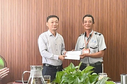 Trưởng Ban Quản lý bán đảo Sơn Trà và các bãi biển du lịch Đà Nẵng Nguyễn Đức Vũ biểu dương và khen thưởng đột xuất cho anh Phan Thanh Trinh, Tổ trưởng Tổ công tác số 2. (Ảnh: HT)