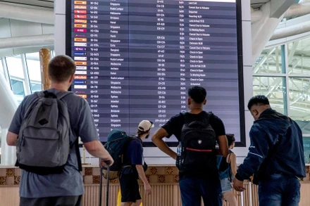 Hành khách xem thông tin trên bảng điện tử tại sân bay quốc tế I Gusti Ngurah Rai ở Bali, Indonesia. (Ảnh: XINHUA)