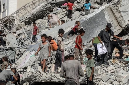 Người dân Palestine tại khu vực một tòa tháp bị phá hủy sau cuộc không kích của Israel vào thành phố Gaza ngày 6/9/2025. (Ảnh: XINHUA).