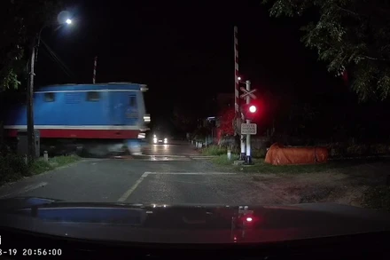 Gác chắn tàu tự động mở khi tàu hỏa lao đến. (Ảnh: Cắt từ clip)