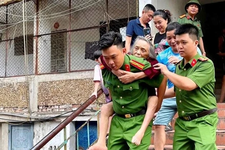 Công an phường Thành Vinh (Nghệ An) hỗ trợ người dân ở các khu chung cư cũ sơ tán để tránh nguy hiểm do mưa bão.