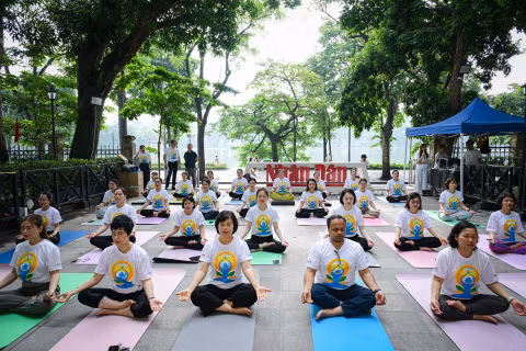 Các đại biểu, cùng đông đảo phóng viên, biên tập viên, người lao động Báo Nhân Dân tham gia màn đồng diễn Yoga tại khuôn viên trụ sở Báo Nhân Dân tại Hà Nội. (Ảnh: BẢO LONG)