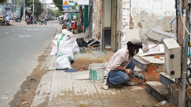 Người dân phường Vĩnh Hội bàn giao mặt bằng, sửa sang nhà ở chuẩn bị thi công Dự án cầu đường Nguyễn Khoái. (Ảnh: THẾ ANH)