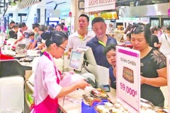 Người tiêu dùng thanh toán tại siêu thị AEON. (Ảnh ĐỖ TÂM)