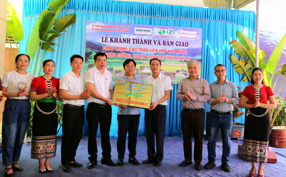 Lãnh đạo Báo Sức khỏe và Đời sống cùng nhà tài trợ trao biển tượng trưng cầu tràn liên hợp Khe Măng cho địa phương. z6684119430650-7c5f87caa365059dbd34855b7732de84.jpg
