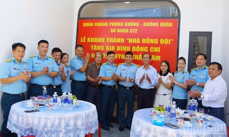 Các đại biểu dự buổi khánh thành và bàn giao “Nhà đồng đội” chụp ảnh lưu niệm với gia đình Đại úy Huỳnh Khắc Tâm. (Ảnh: VĂN TÂM)