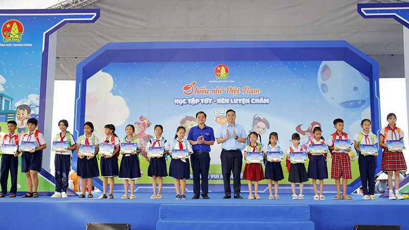 Ban tổ chức trao học bổng tặng học sinh vượt khó học tốt tại ngày hội.